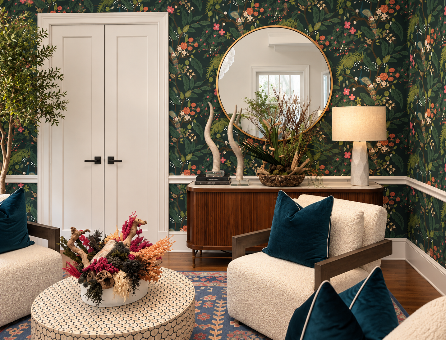 A floral wallpapered sitting room with cream chairs and a flower arrangement