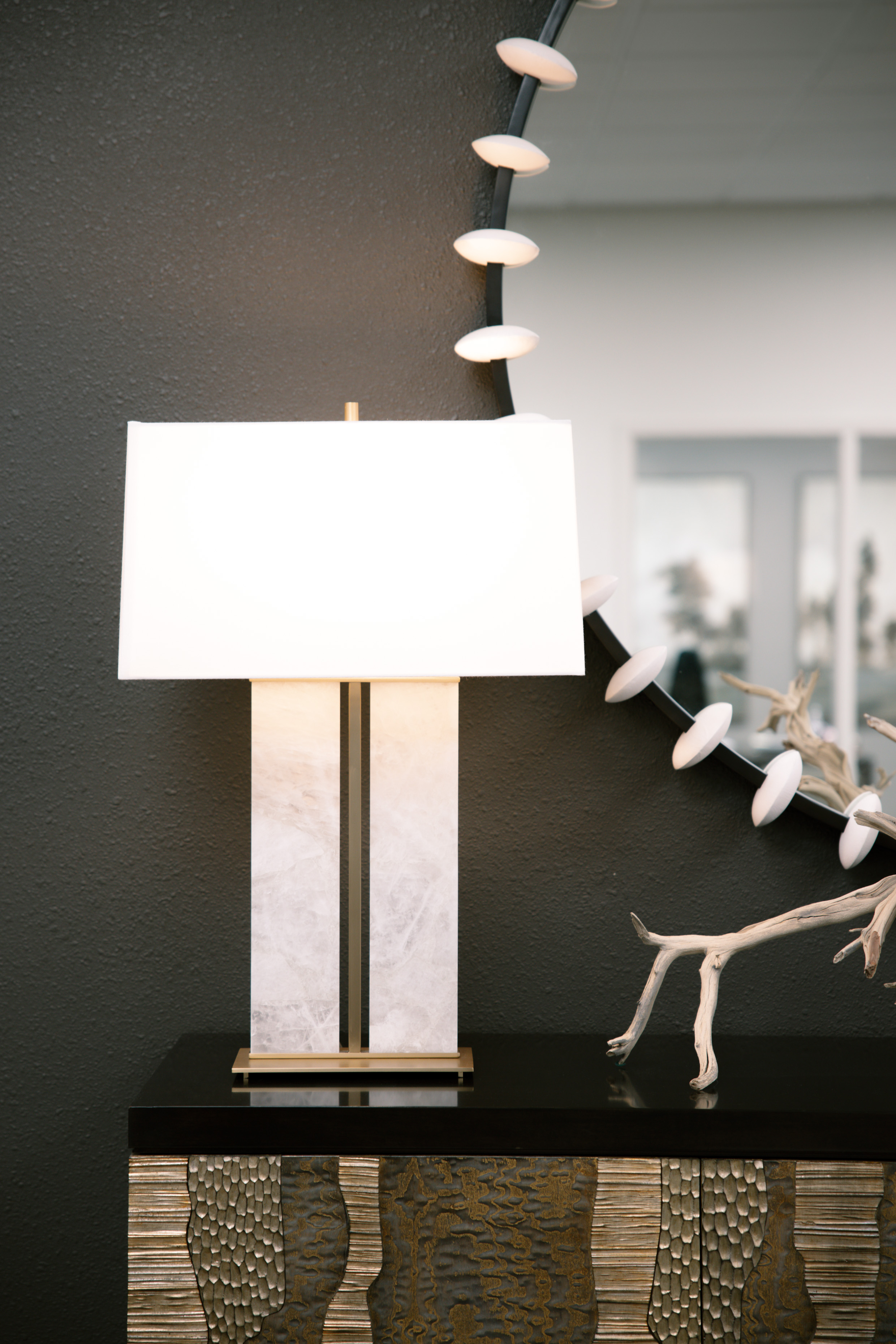 A sculptural floor lamp against a dark charcoal wall