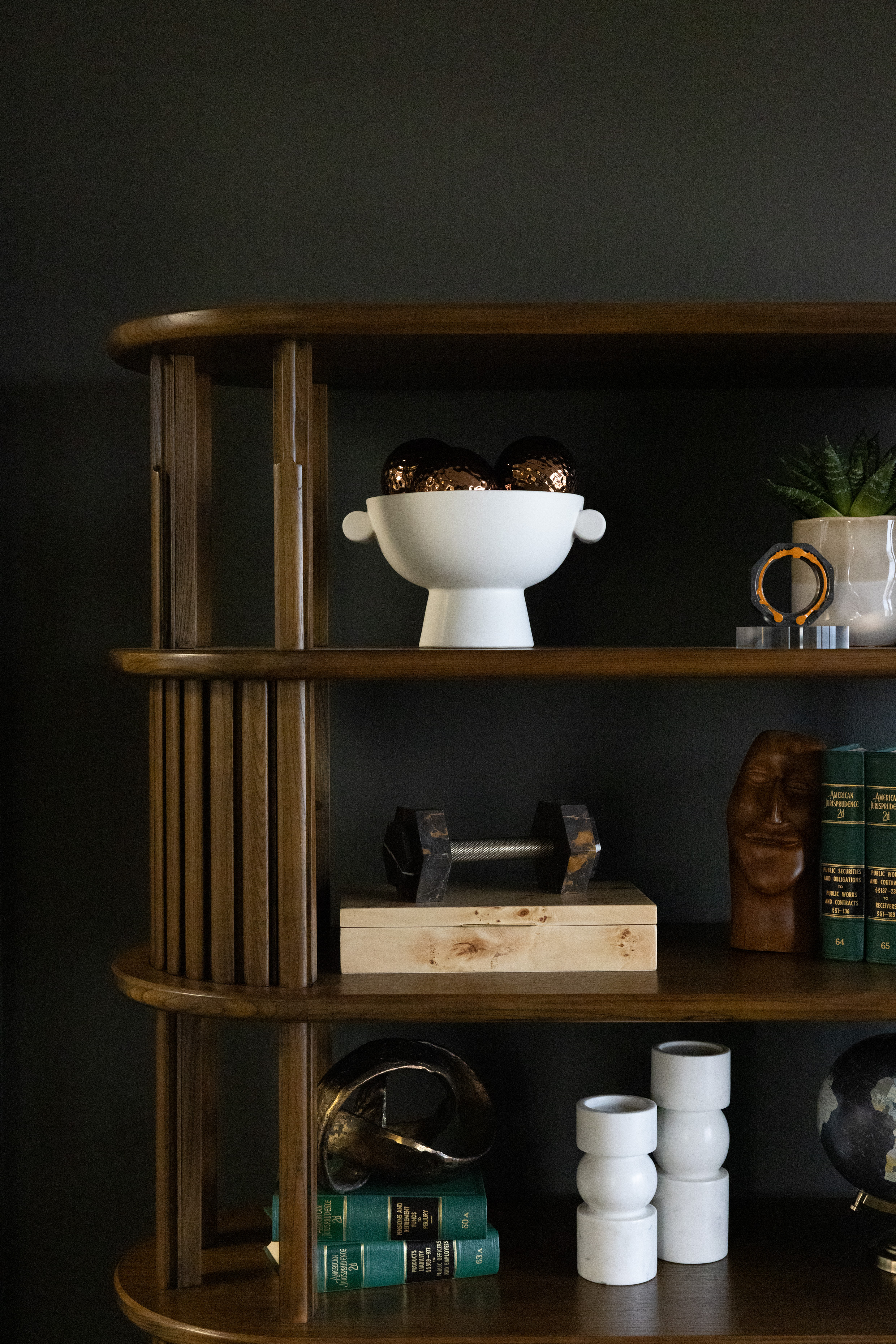 Dark built-in shelves styled with ceramics and collected objects