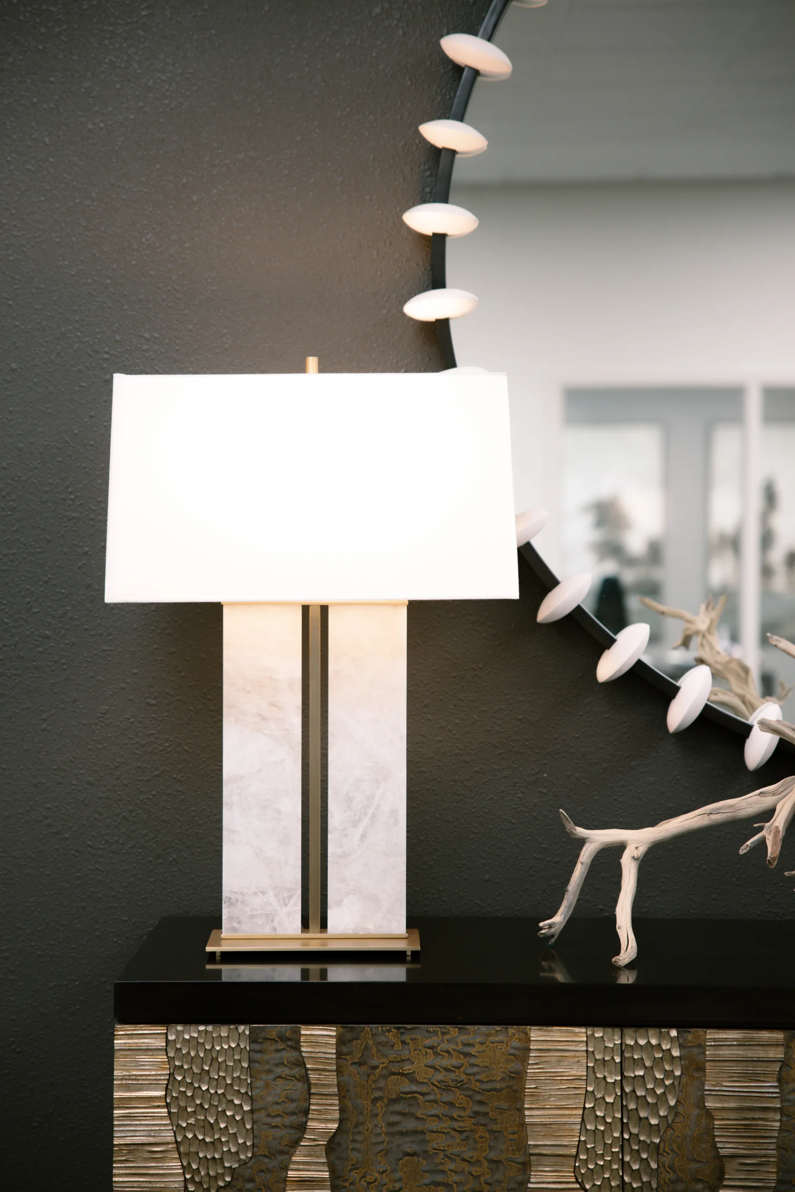 A sculptural floor lamp against a dark charcoal wall
